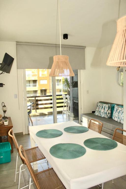a dining room with a white table and chairs at Depto 24 Punta Pampa in Las Gaviotas