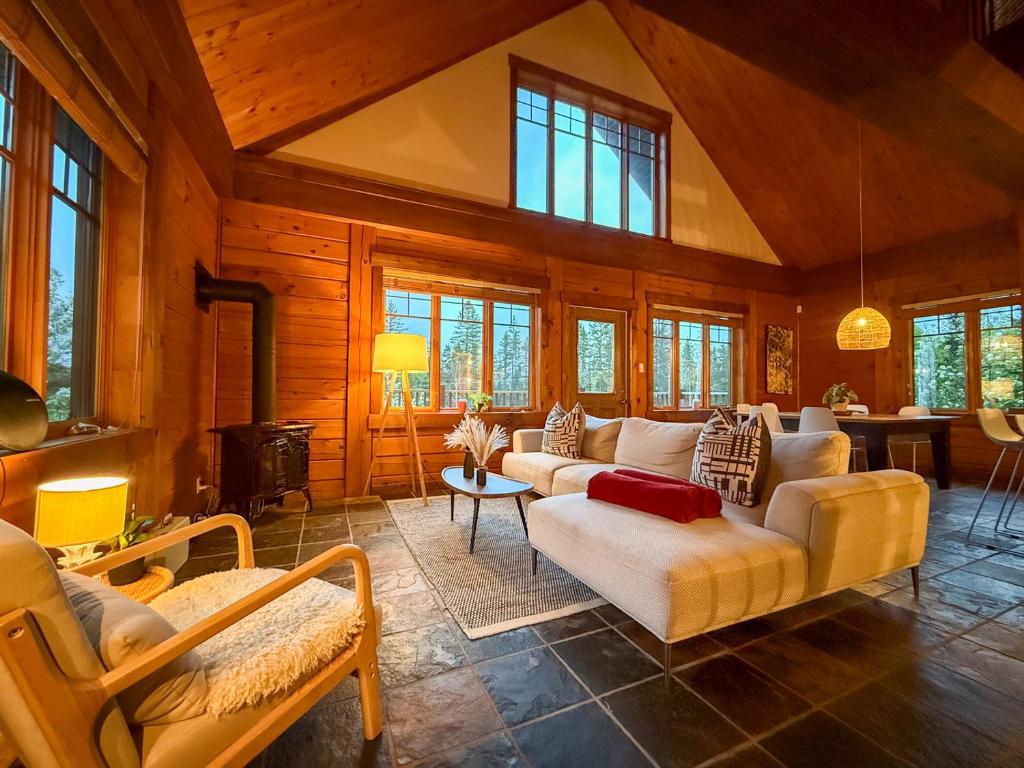 a large living room with couches and a fireplace at Sara Chalet With Hot Tub, Hiking Trails in Notre-Dame-de-la-Merci