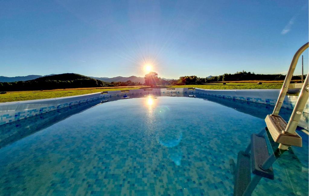 una piscina con il tramonto sullo sfondo di Beautiful Home In Debelo Brdo I a Debelo Brdo