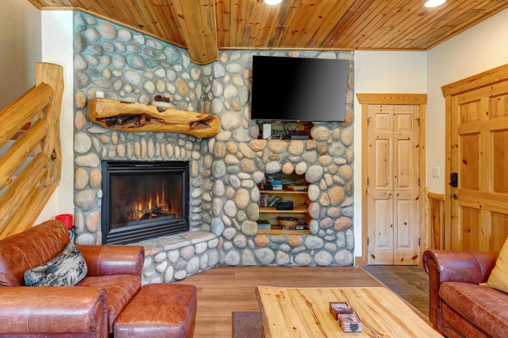 a living room with a stone wall with a fireplace at Timber Wolf Lodge 7C condo in Park City