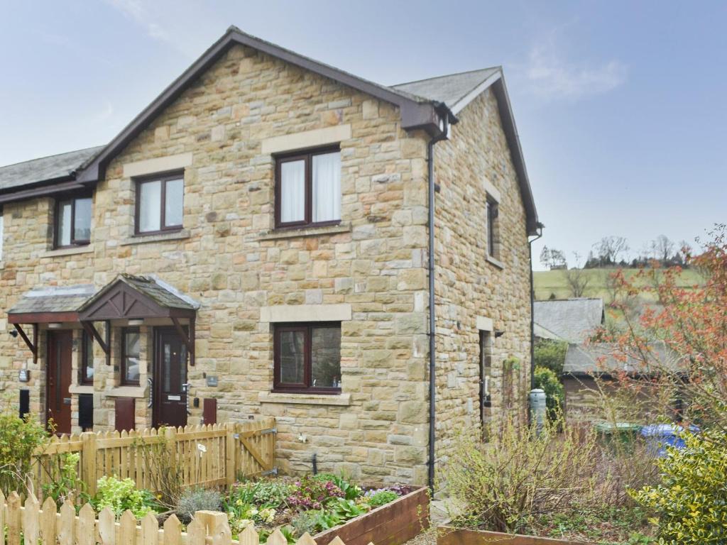 a stone house with a garden in front of it at Rothbury Cottage in Rothbury