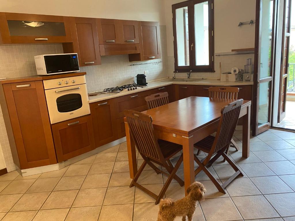 a kitchen with a wooden table and a dog in it at Annina residence in Ravenna