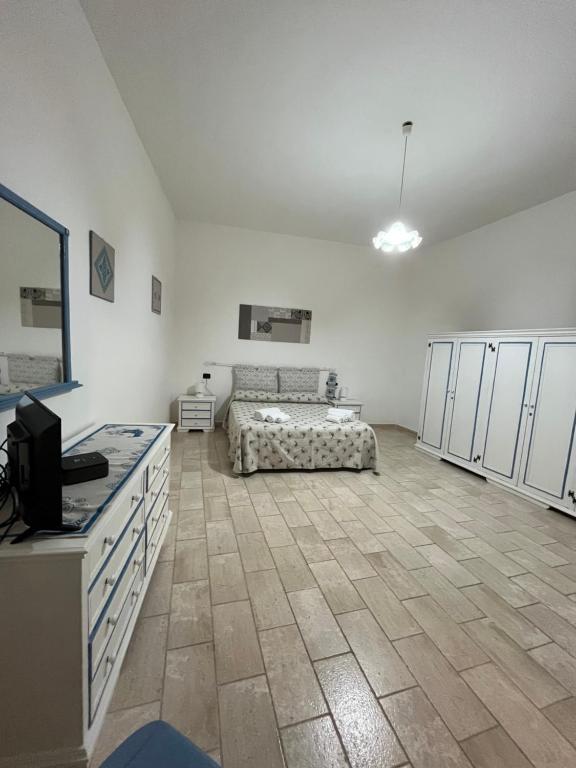 una grande camera bianca con un letto e una cucina di Casa La Pavoncella a Orosei