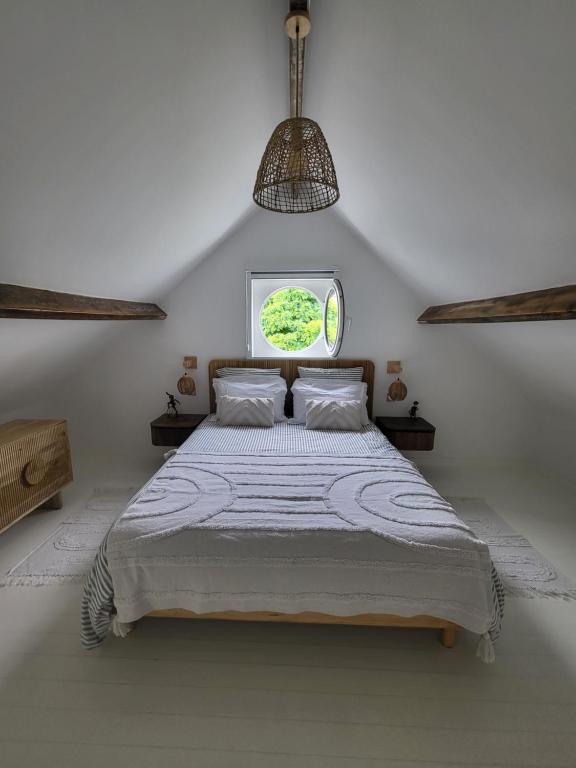 ein Schlafzimmer mit einem großen Bett mit Fenster in der Unterkunft La petite maison blanche in Dunkerque