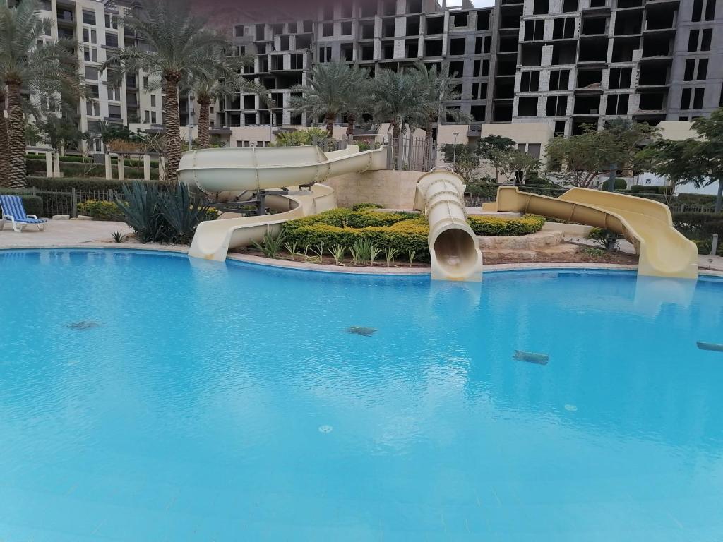 a large swimming pool with a water slide at Al RAHA village - Aqaba أستوديو بقرية الراحه العقبة مرسى زايد in Aqaba