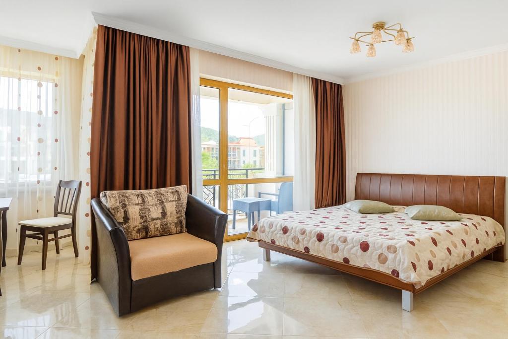 a bedroom with a bed and a chair and a window at Romantic Studio Florence in Sveti Vlas