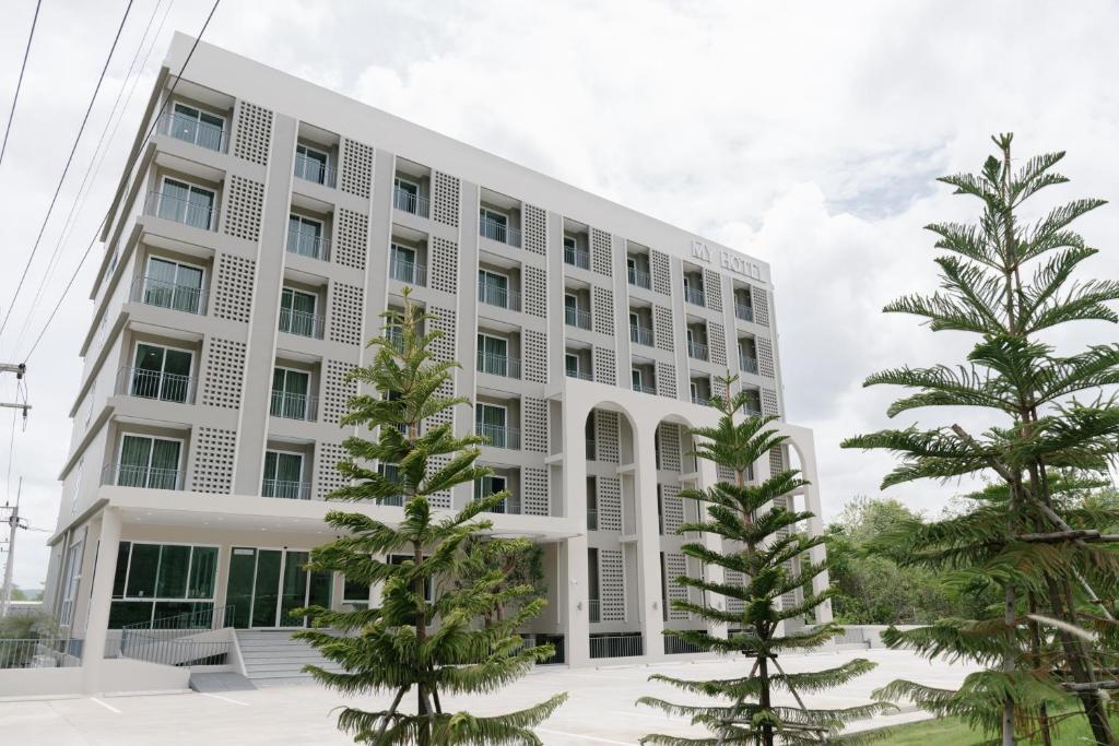 a white building with trees in front of it at My Hotel Kanchanaburi in Ban Chuk Kum