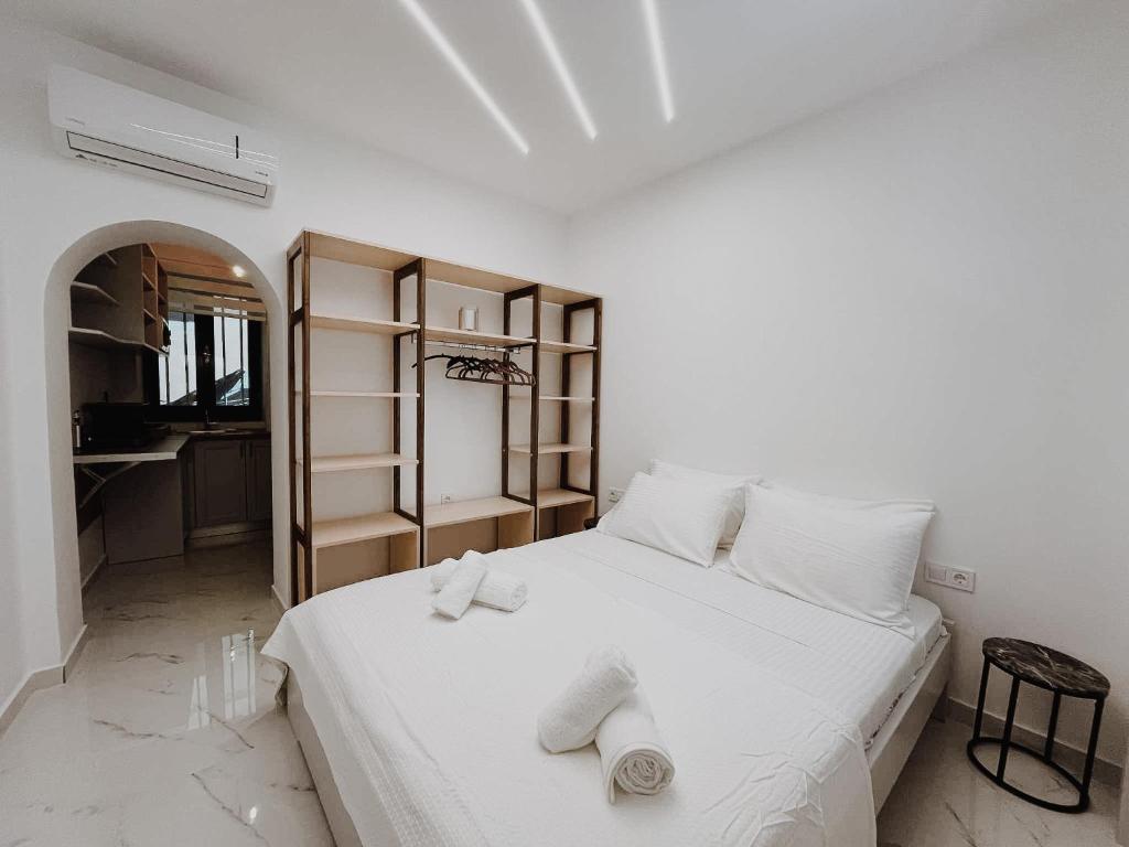 ein Schlafzimmer mit einem weißen Bett mit Handtüchern darauf in der Unterkunft Venetian Vicolo by CorfuEscapes in Korfu-Stadt