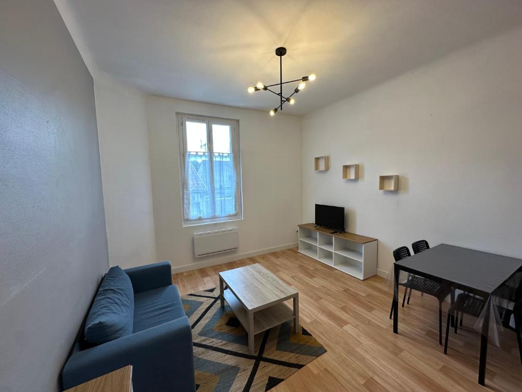 a living room with a blue couch and a table at Montsejour - Superbe T2 rénové in Tarbes