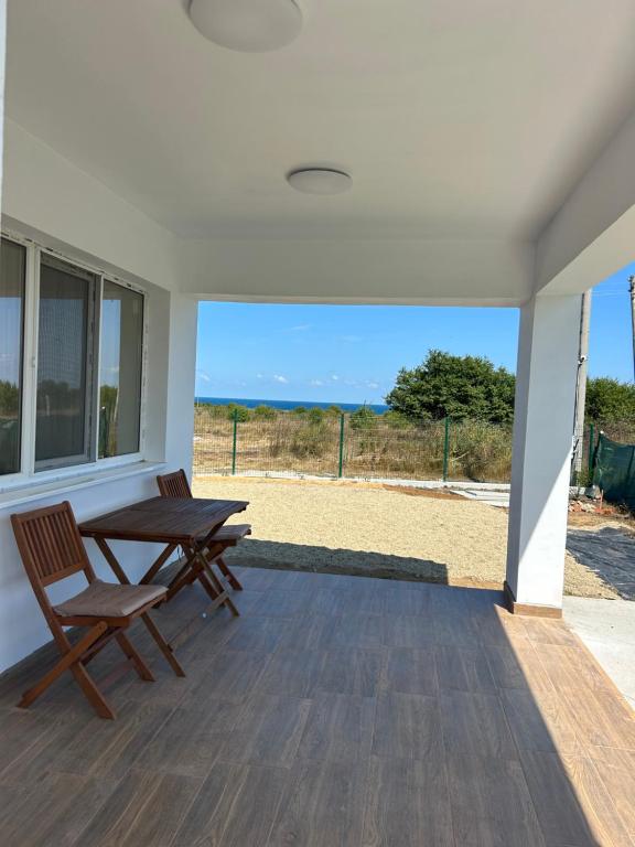 a patio with a table and chairs and a view of the beach at Vila Nikalas in Tyulenovo