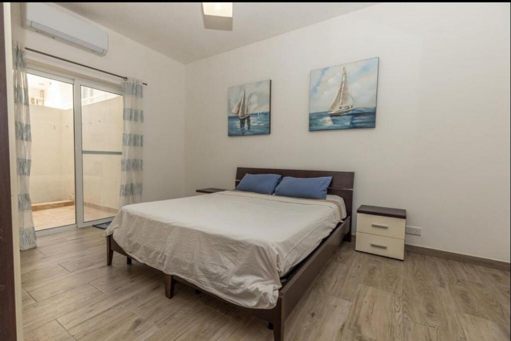 セント・ポールズ・ベイにある3 bedroom appartment in st paul bayのベッドと大きな窓のある寝室