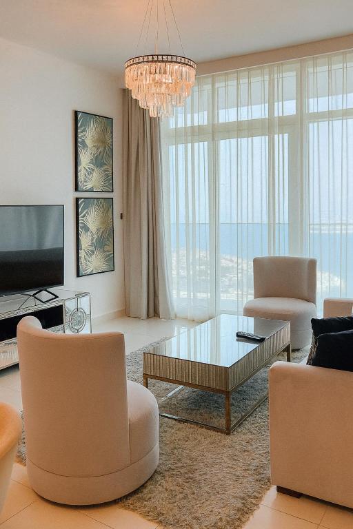 a living room with a chandelier and a table and chairs at Best Emaar Beachfront view one bedroom in Dubai