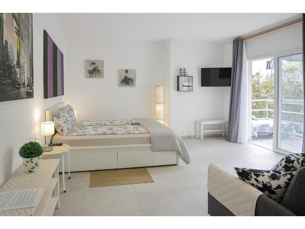 a white living room with a bed and a couch at Fantastico 4 - with large private terrace, free parking, air conditioning, BBQ in Puerto de la Cruz