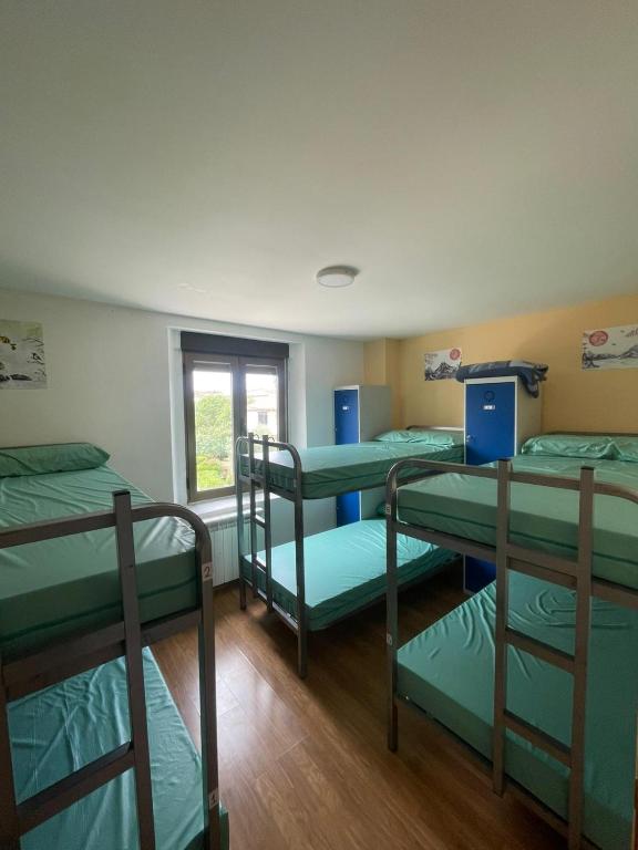 four bunk beds in a room with a window at Albergue de Espinosa in Espinosa del Camino