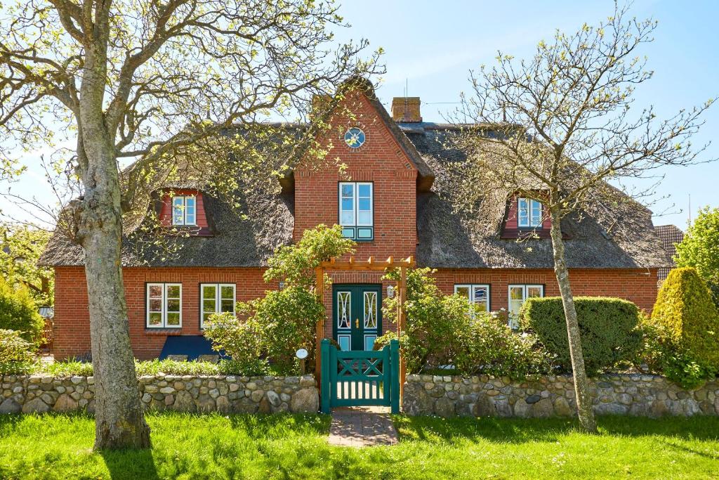 a large red brick house with a green door at Annes Cottage 2 in Oevenum
