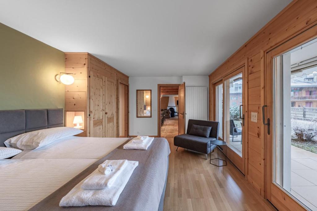 a bedroom with two beds and a chair and a window at Ride Inn Verbier - B&B - private room and ensuite bathroom in Verbier