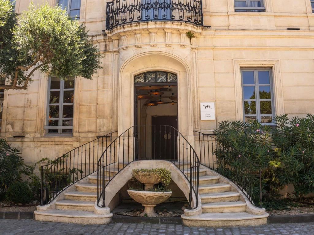 a building with a staircase in front of a building at Mercure Arles Centre Arenes in Arles