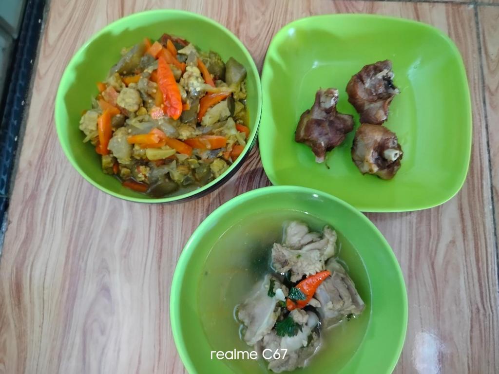 three green plates of food on a table at Atta Ratu Homestay komodo in Komodo