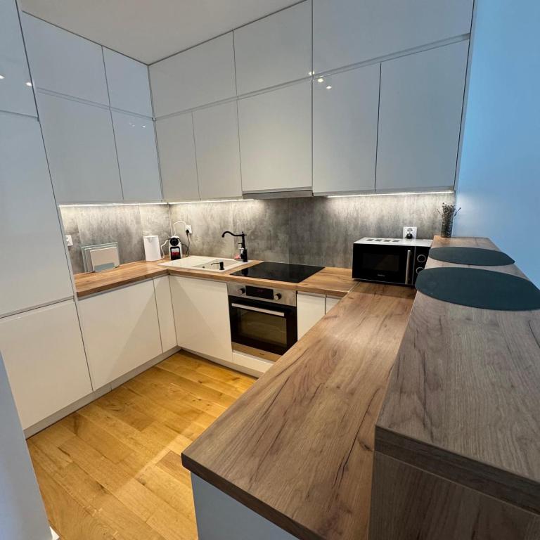 Una cocina con gabinetes blancos y encimera. en Lubelska SkyRes City View & Free Parking, en Rzeszów