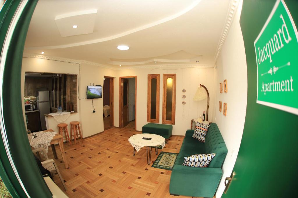 a living room with a green couch and a table at Jacquard Apartment in the centre of Kutaisi in Kutaisi