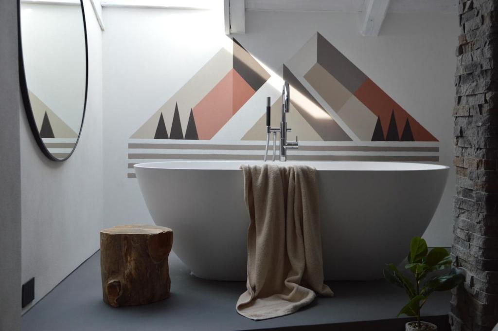 a bathroom with a white tub and a window at Mountain Suite with tub and view, Alpine design in Sanzeno