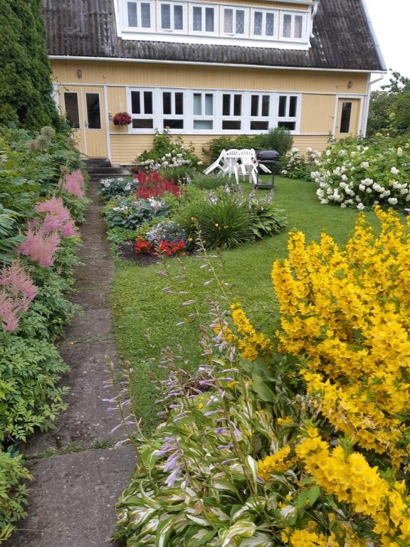 a garden with flowers in front of a house at Aliise Garden Guesthouse in Pärnu