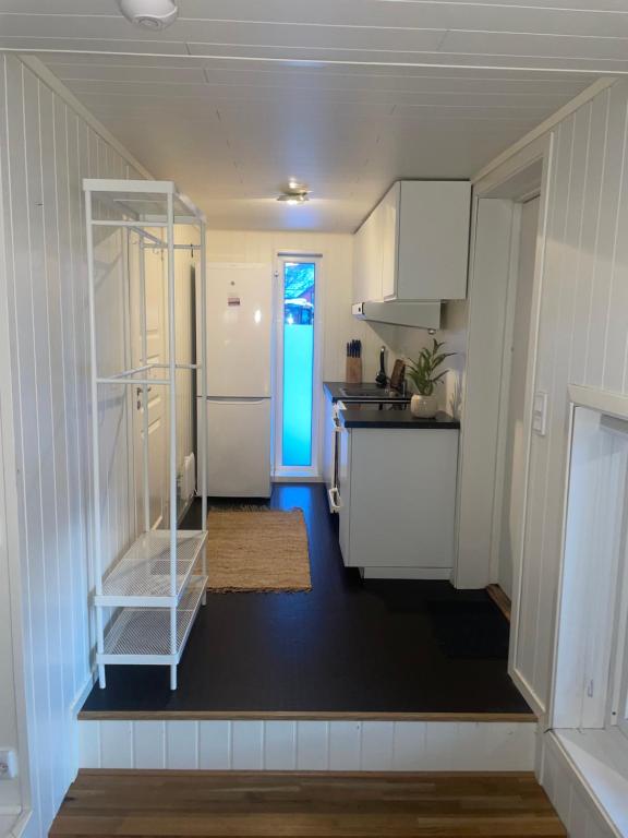 eine Küche mit weißen Schränken und einer Theke in der Unterkunft Studio appartment in private home at Bjerkaker in Tromsø