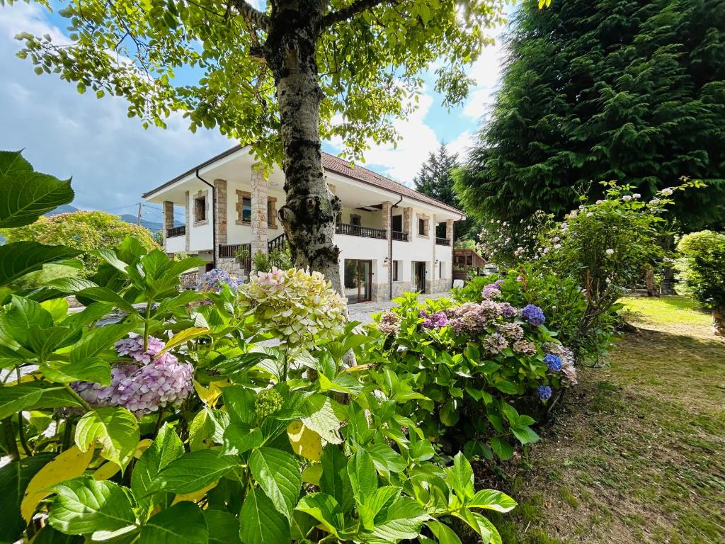 ein Haus mit vielen Blumen davor in der Unterkunft Casa Rural Raiz y Cumbre in Con