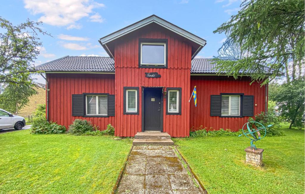 a red house with a black door on a green yard at 3 Bedroom Amazing Home In Sjötofta in Sjötofta