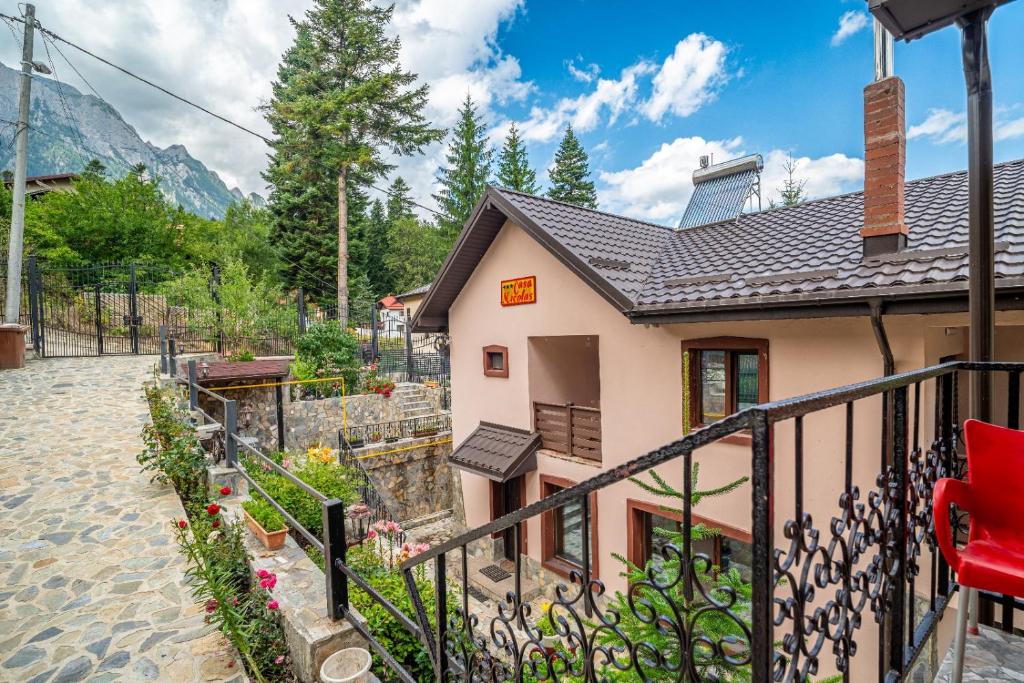 a house with a fence next to a garden at Casa Nicolas Busteni in Buşteni