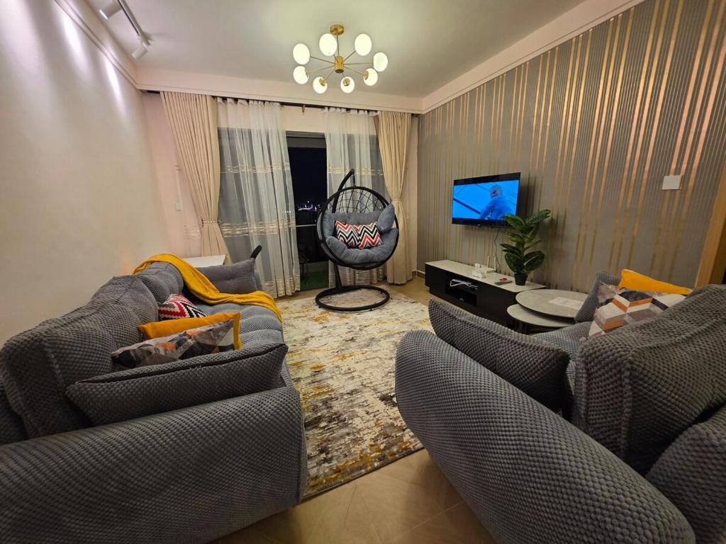 a living room with two couches and a television at C7 Haven Artesano in Nairobi