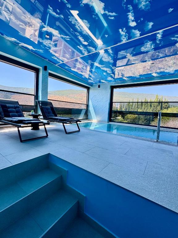 a room with two chairs and a swimming pool at S-Penthouse in Herceg-Novi