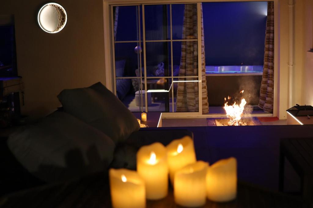 una stanza con un divano con candele davanti a una finestra di Li li et rose - Suite avec jacuzzi privatif a Nantes