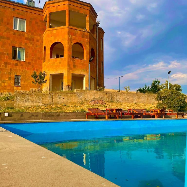 a building with a swimming pool in front of a building at Lernarot Guest House in Lernarot