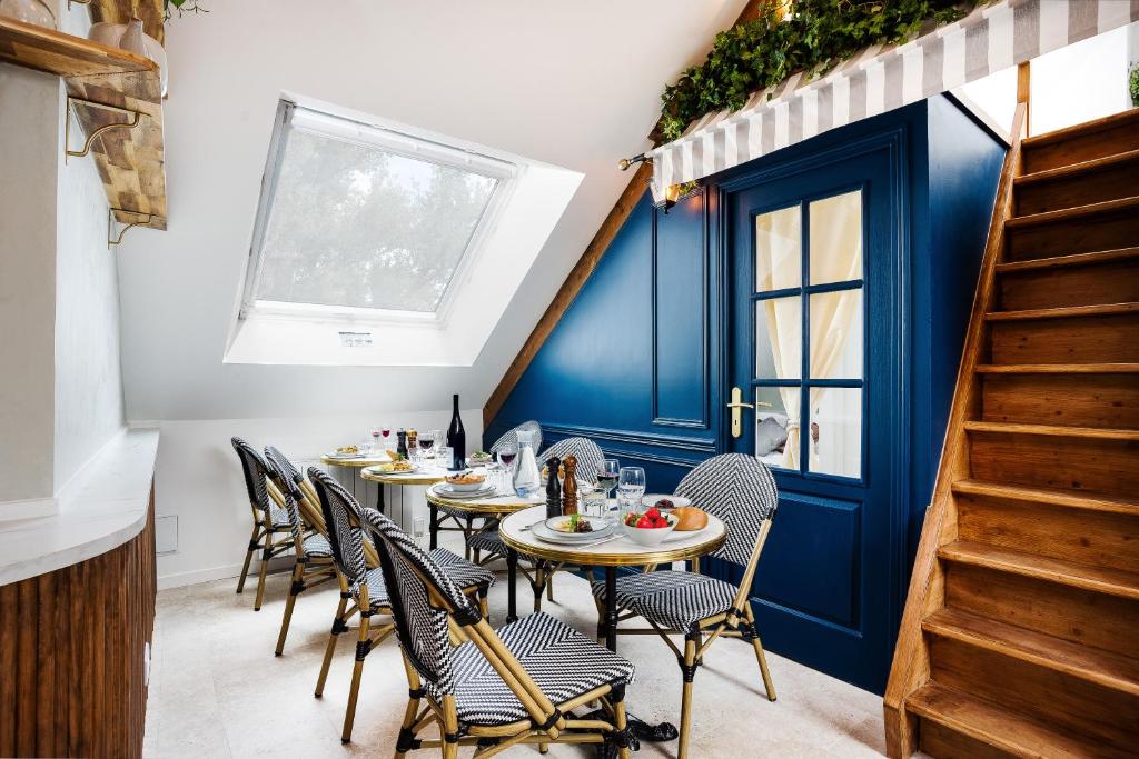 a dining room with tables and chairs and a blue door at Le petit Paris in Villejuif