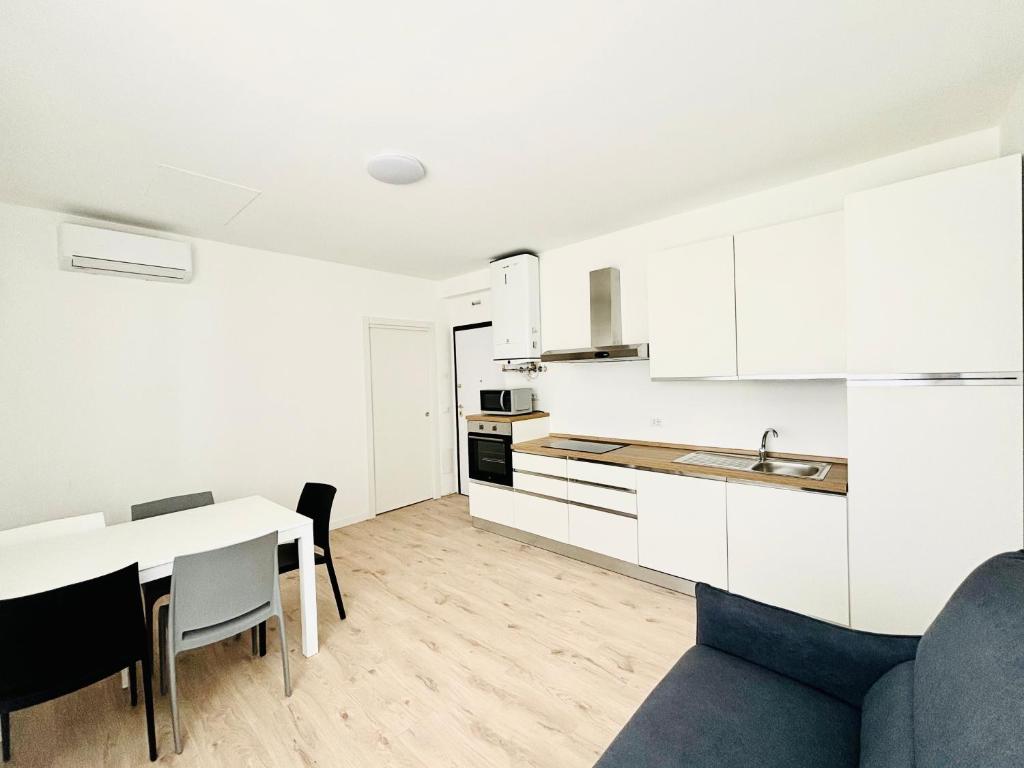 a kitchen and dining room with white cabinets and a table at Verga - 100 m da Piazza Mazzini - Immobil Relax in Lido di Jesolo