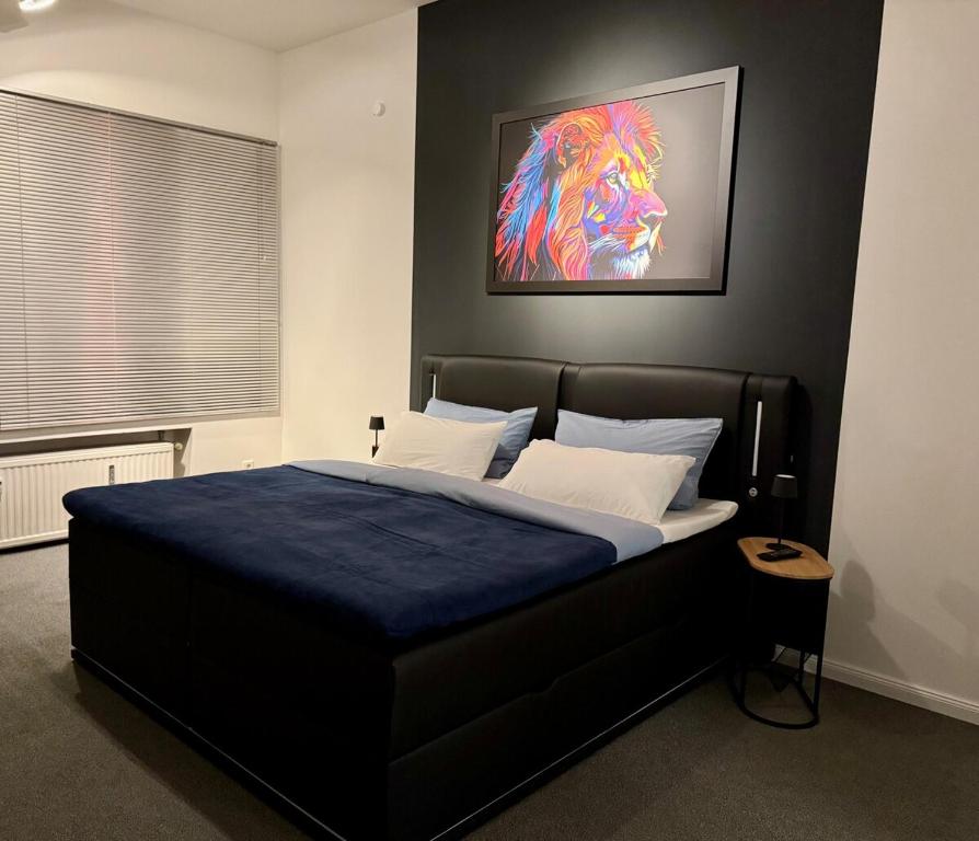 a bedroom with a bed with a lion painting on the wall at Modernes Apartment bei Düsseldorf in Meerbusch
