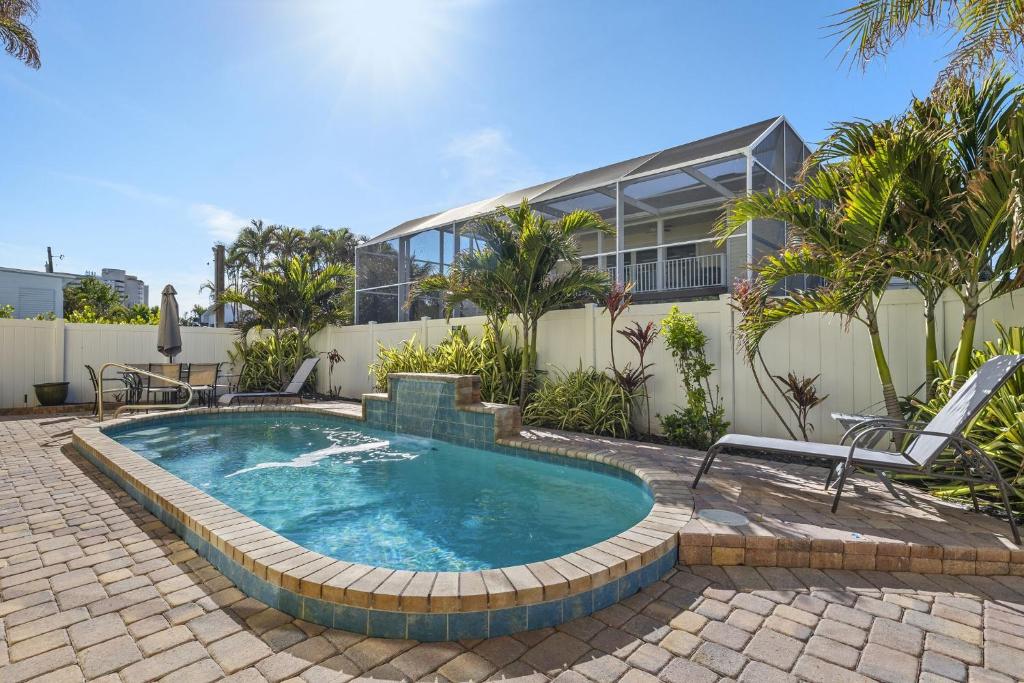 a swimming pool in front of a house at 241 Oasis Pearl- 3BR Pool Home! home in Fort Myers Beach