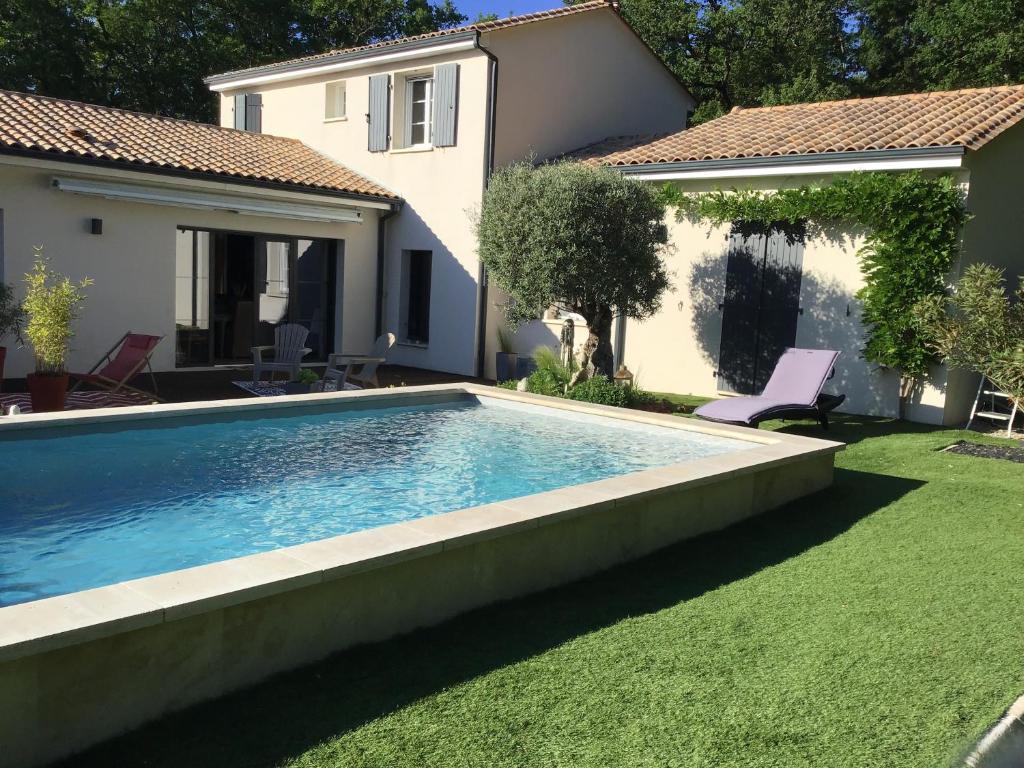 a swimming pool in a yard next to a house at Havre de paix avec 2 chambres et salle de bain in Claix
