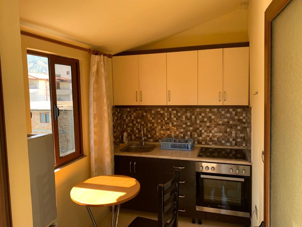 a kitchen with a stove and a sink and a table at Luna Apartment in Berat
