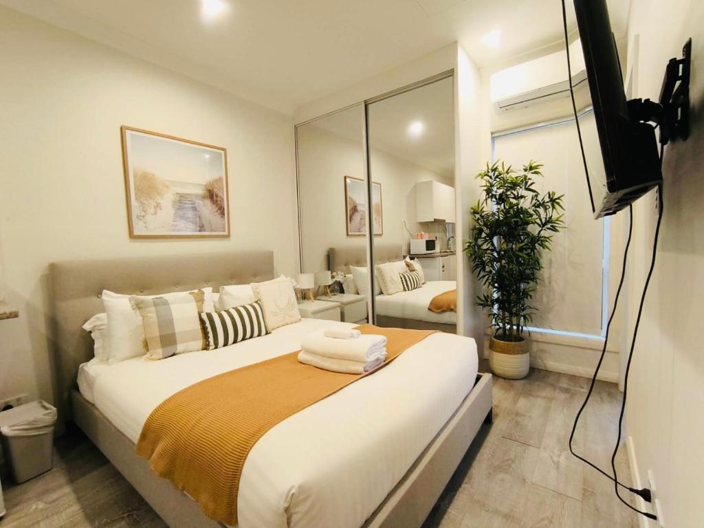 a bedroom with a large bed and a mirror at Peaceful Studio Hidden in Kingsgrove in Sydney
