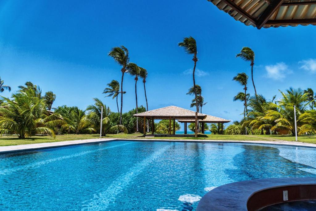 una piscina con gazebo e palme di Gostoso RN Casa em Condomínio Piscina Churrasqueira privativas frente ao Mar a São Miguel do Gostoso