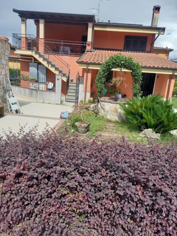 a house with a large purple bush in front of it at Anna's Little House, Cinque Terre, Lerici in Arcola
