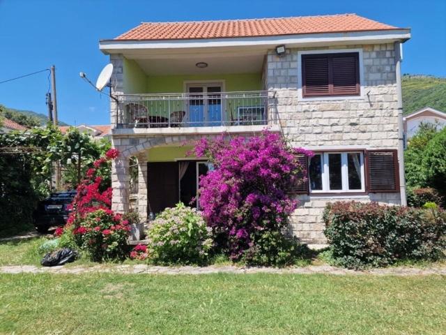 a brick house with flowers in front of it at Boka Garden in Bijela