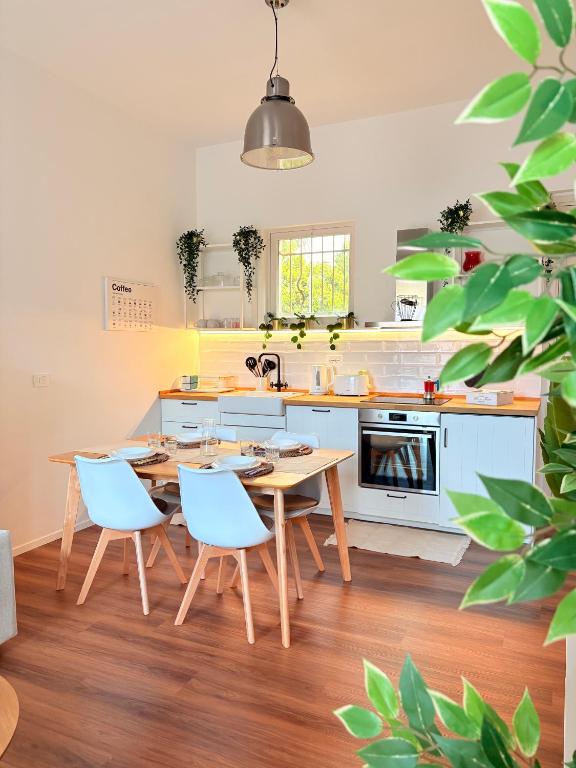 a kitchen with a wooden table and blue chairs at StayHub-RHO in Rho