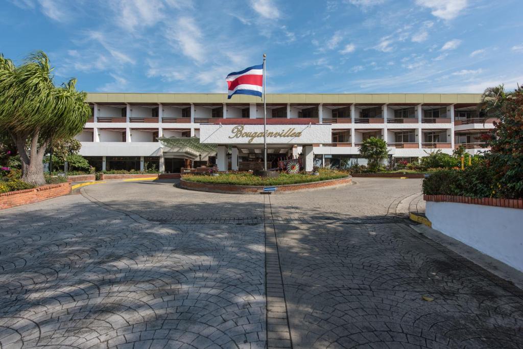 ein Gebäude mit einer Flagge davor in der Unterkunft Hotel Bougainvillea San José in Santo Domingo