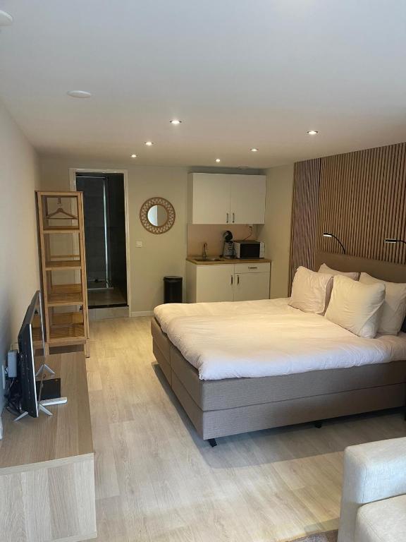 a bedroom with a large bed and a kitchen at Studio Alexander with private indoor parking in Zandvoort