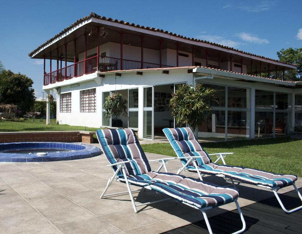 dos sillas de jardín sentadas frente a un edificio en Finca Hotel Villa Clara, en Chinchiná