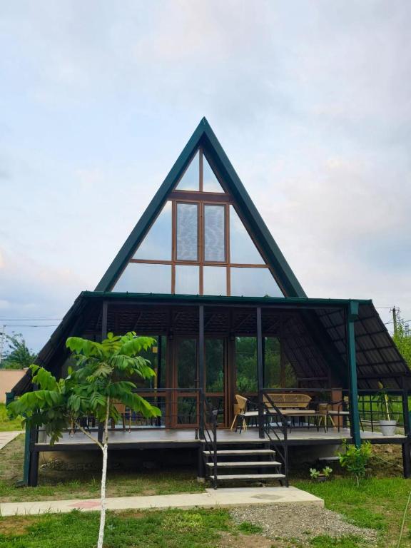a house with a thatched roof with a porch at Kutaisi Red Water Cottage in Odilauri