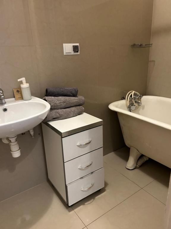 a bathroom with a sink and a tub and a toilet and a sink at Planty Apartament in Kraków